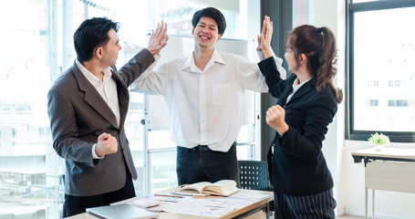 Successful business people celebrating teamwork in the office.