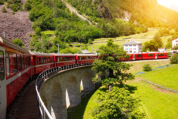 Obraz premium Red train moving on vaiduct in summer in Switzerland