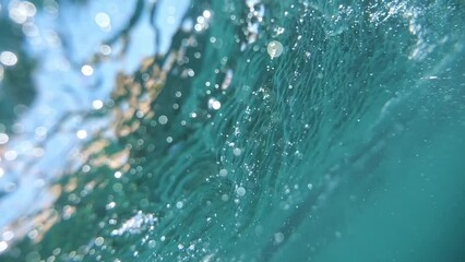 Floating bubbles and twirling particles in azure marine depth, captured in a slow cinematic style.