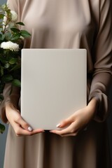 Naklejka premium a woman holding a blank grey notebook close-up