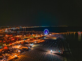 Ferris wheel on the seaside of Rimini, evening shot from a drone. Vacation and tourism concept