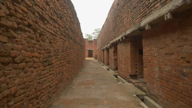 Inside a narrow lane of a ruined monastery with intricate brick masonry walls and rooms excavated at the site of Nalanda Mahavihara an ancient Buddhist Monastic University in Bihar India