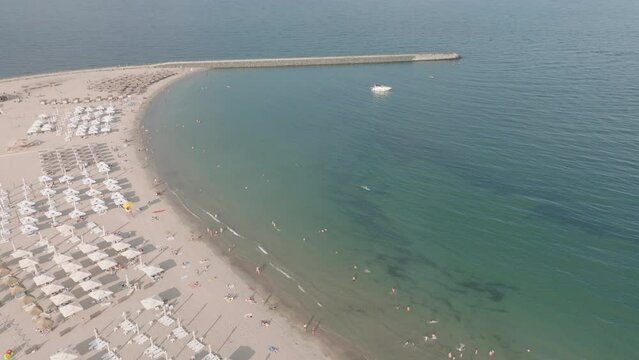 Tourists On Summer Vacation At Reyna Beach And Pier In Constanța, Romania. Aerial Drone Shot