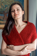 Lifestyle portrait of mid adult woman looking at camera at home. Nice female face smiling. Green Eyes. Brown-haired mature middle aged lady put on a knitted shawl or scarf. Age from 30 to 40, 45 years