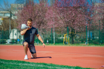 Young muscular man doing exercises with kettlebell outdoor. Weightlifting workout. Sports, fitness concept.