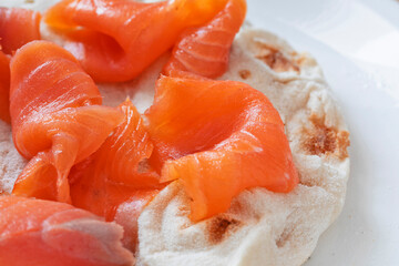 Macro close up of italian 'Pinsa' with smoked salmon.
