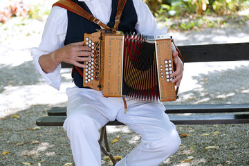 Senior man playing the accordion in traditional clothes