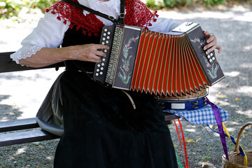 Senior woman playing the accordion in traditional clothes