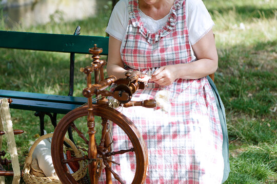 Young woman using a spinning wheel