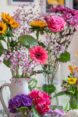 Obraz na płótnie Canvas Schöne bunte Blumensträuße in gelb und rosa in Vasen dekorieren ein gemütliches Zuhause