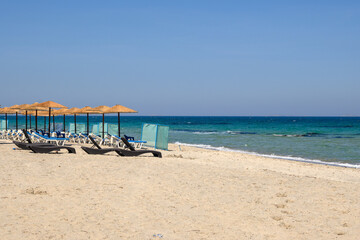 Sunbeds with umbrella on sandy beach of Marmari. The Greek island of Kos