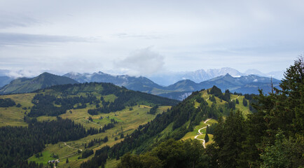Naklejka na ściany i meble Meadow hill in Alps mountain valley with fog. Austria landscape background