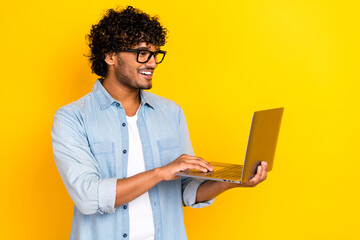 Profile portrait of cheerful it specialist toothy smile use apple microsoft netbook isolated on yellow color background © deagreez