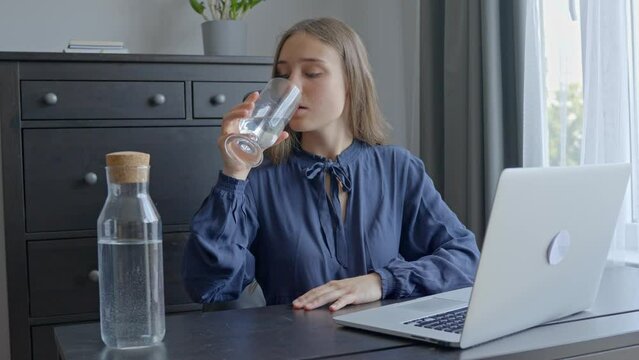 Importance of staying hydrated when working in office at laptop