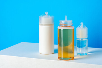 Black electronic cigarettes liquid bottles on blue background