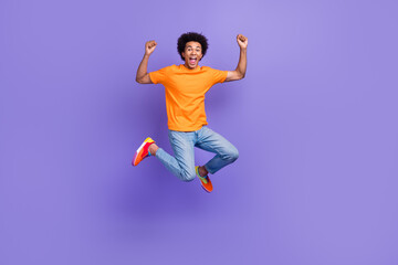 Fototapeta na wymiar Full body cadre of careless jumping tourist guy summertime big sale abroad travel fists up holidays isolated on purple color background