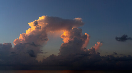A big O-shaped cloud. Evening pink and blue sky. 