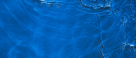 Transparent dark blue clear water surface texture with ripples and splashes. Abstract summer banner...