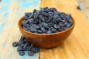 Dried Black raisins in a wooden bowl 