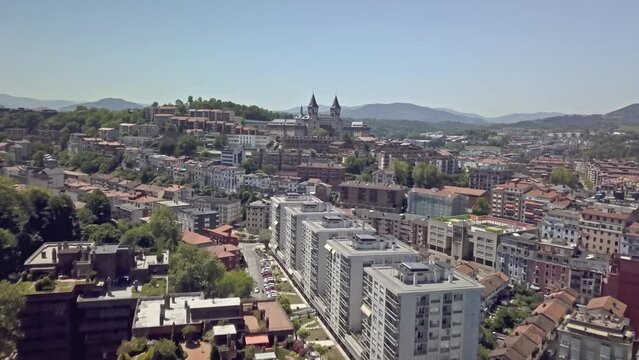 Drone shot flying over apartment rooftops of San Sebastian, Spain towards Elizbarrutiko Seminarioa and Parque de Serafin Baroja.