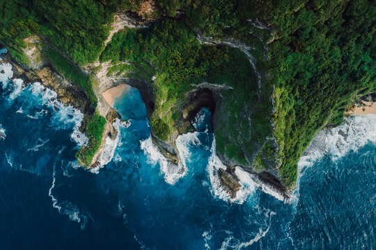 Landscape with coastline, rocks and blue ocean with waves in Indonesia. Aerial view.