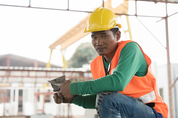 Asian male builder worker working at construction site. Male mason working at construction site