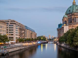 View of the city river at the cathedral in Berlin at sunset. Landscape of the evening city