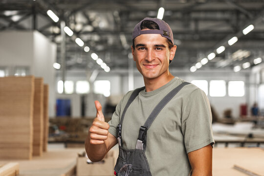 Portrait of young male carpenter standing in the wood workshop