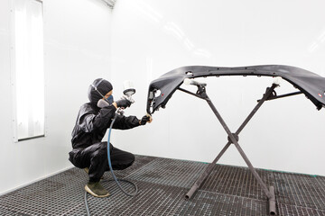 Automotive Paint. Mechanic Painting the Car in Auto Repair Shop