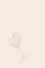 Vintage crystal glasses scattered on a beige background. Selective focus.