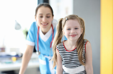 Portrait of happy little girl posing while looking at camera after good consultation with pediatrician. Medical services doctor pediatrician concept