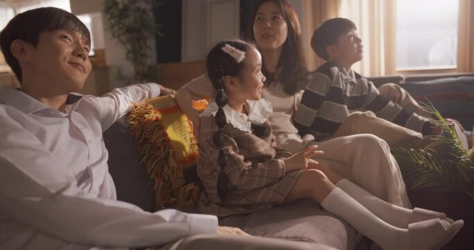 Portrait of Happy Small Korean Family Talking Together in Their Sunny Home. Parents Communicating, Being Affectionate with Their Children, Validating and Listening to Them. Family Having a Discussion