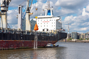 Bulk carrier  in the southwest port of Hamburg for loading and unloading at the quay. Fright transport and container shipment is a significant economic factor for the city of Hamburg 