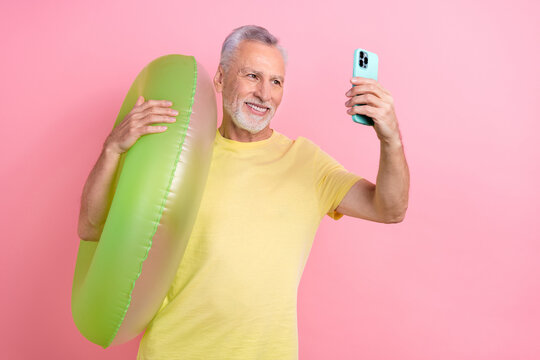 Photo of pensioner blogger man white beard gray hair selfie video bring inflatable ring swimming pool isolated on pink color background