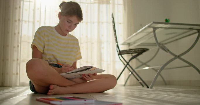 Crafting Beauty: Creative Moments with a Teen Girl Drawing Colorful Pencils in the Comfort of Home. High quality 4k footage