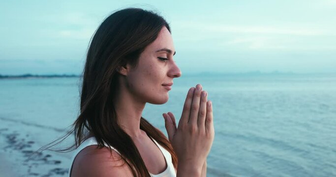 Christian woman hand praying. Woman prays in the morning on sea background. Believer woman praying to God. Power of hope or love and devotion. Spirituality and religion concept
