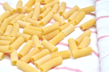 a set of dry rigatti noodles positioned on a white cloth