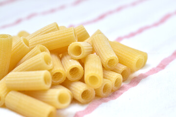 a set of dry rigatti noodles positioned on a white cloth