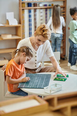 girl writing on chalkboard near numbers, learning through play, teacher and kids Montessori concept