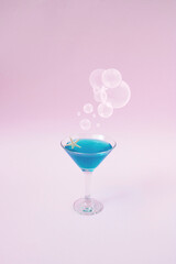 Martini glass with bubble on pink background. Party concept. Creative idea.