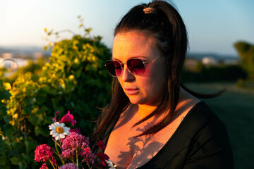 Girl holding flowers at sunset