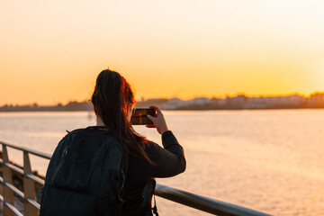 woman taking photo at sunset