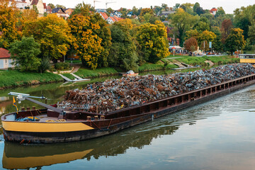 Transportation industry. Ship barge transports scrap metal and sand with gravel. Barge loaded with...