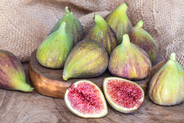 Raw sweet figs on a wooden background closeup. Red - purple e green figs. Figs whole and cut into halves. Organic gardening