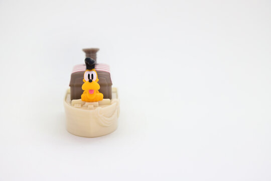 Pluto sailing in a ship seen from the front. Collectible toy for children on white background isolated with copy space. 
