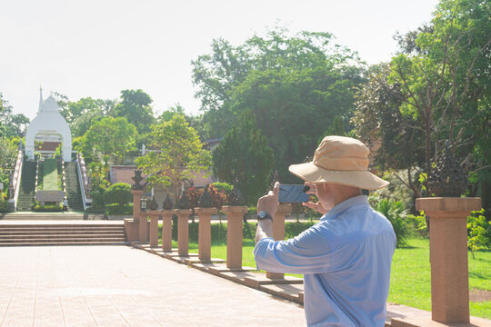 A male tourist uses his cell phone to take photos of the location of Phra That Si Song Rak in Dan Sai District, Loei Province, Thailand.