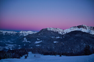 winter landscape in the mountains with snow covered trees, before sunrise