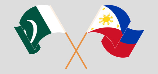 Crossed and waving flags of Pakistan and the Philippines