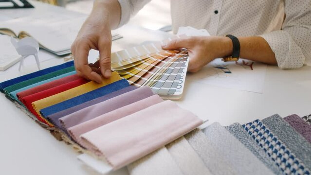 Specialist holding palette with colors and choosing fabrics