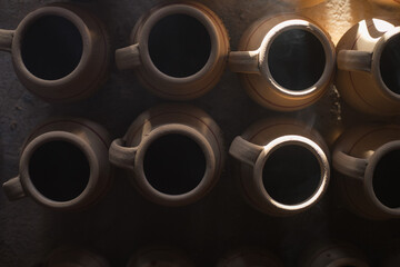 clay pots. Dark photography. Rays of light in the workshop